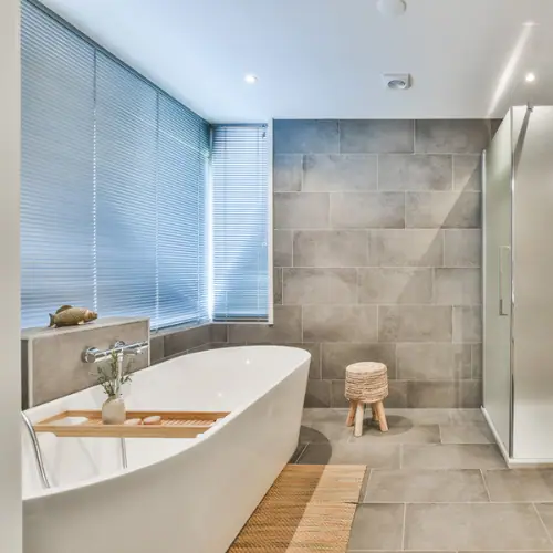 Spa-style bathroom with large gray porcelain tile and freestanding soaking tub