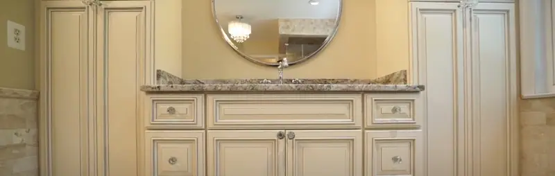 Custom raised-panel cabinetry with antique-white finish and granite countertop