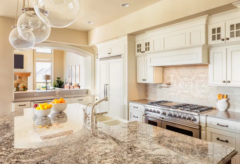 Custom kitchen with granite island, decorative tile backsplash and built-in range hood