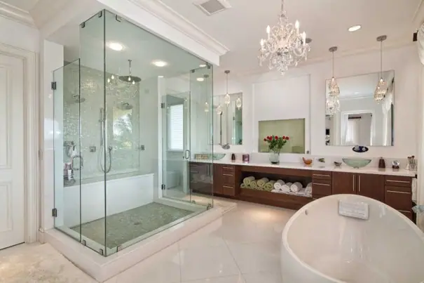 Luxury primary bathroom with glass-enclosed shower, chandelier and freestanding tub