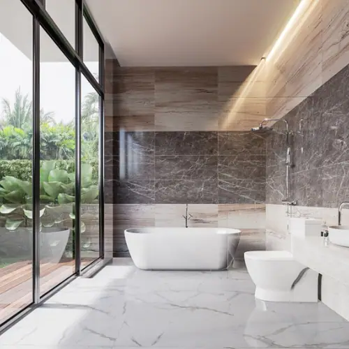 Modern bathroom with freestanding tub beside floor-to-ceiling windows and stone wall tile