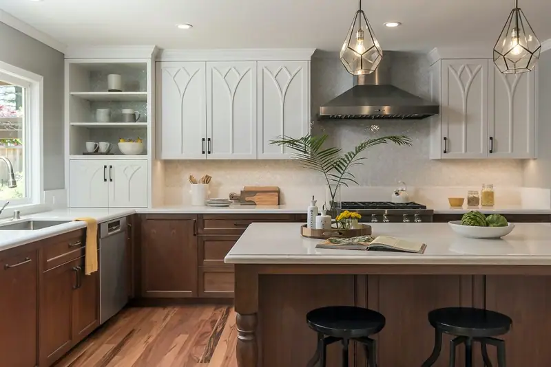 White kitchen cabinets paired with a walnut-stained island and farmhouse pendant lights